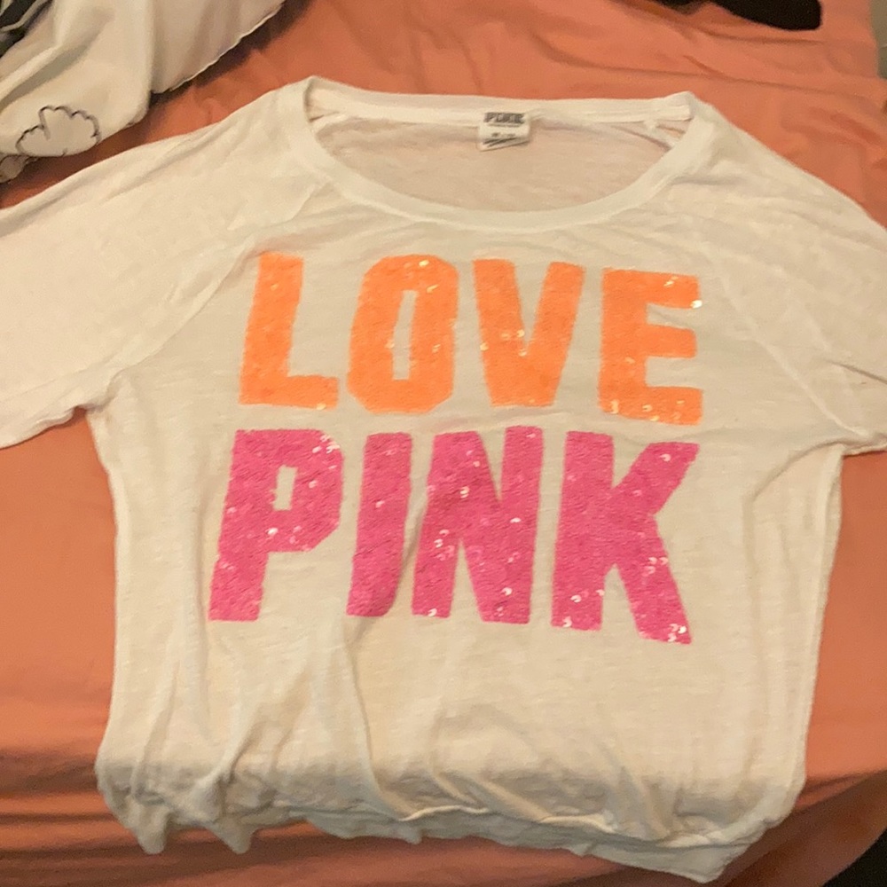 white long sleeve with pink and orange sequins on the front.